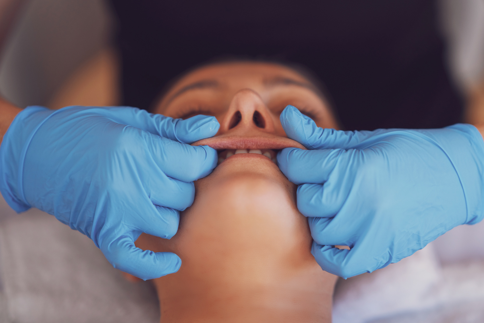 Woman Having Mouth Massage in Blue Gloves